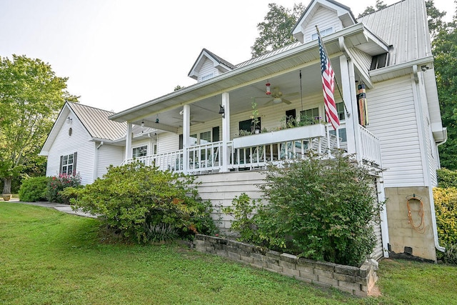 view of property exterior featuring a lawn, ceiling fan, and covered porch