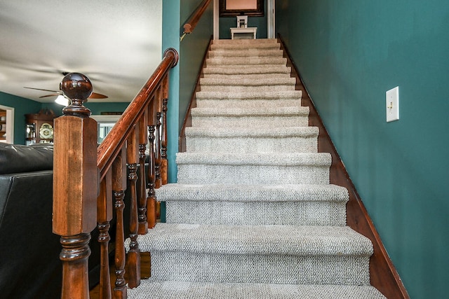 stairway featuring ceiling fan