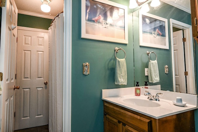 bathroom with tile patterned flooring, vanity, ornamental molding, and a textured ceiling