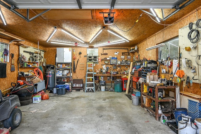 garage with a workshop area and a garage door opener