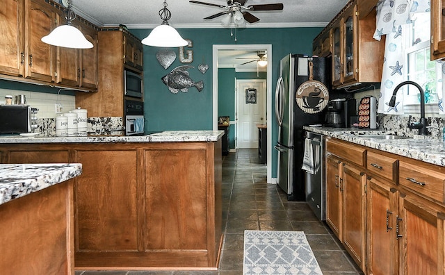 kitchen featuring backsplash, sink, ornamental molding, appliances with stainless steel finishes, and decorative light fixtures