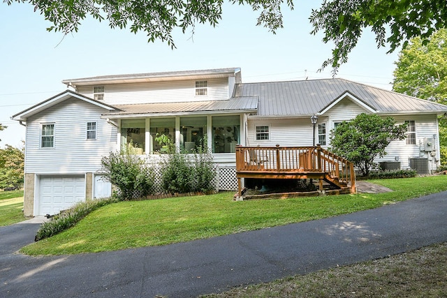 view of front of property featuring a front yard, a garage, and central air condition unit