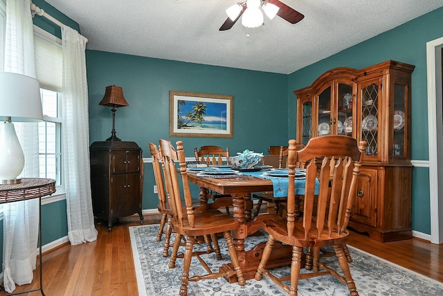 dining area featuring ceiling fan, a textured ceiling, and hardwood / wood-style flooring