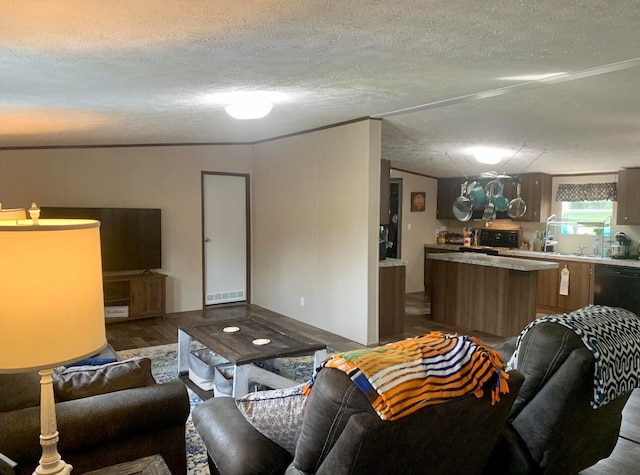 living room with hardwood / wood-style flooring, crown molding, and a textured ceiling