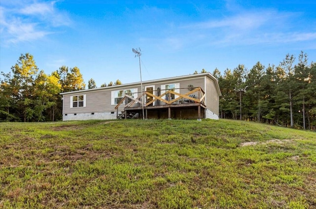 rear view of property with a deck and a lawn