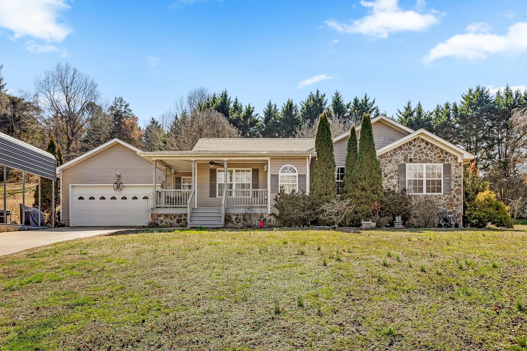 view of front of house featuring covered porch, a front yard, and a garage