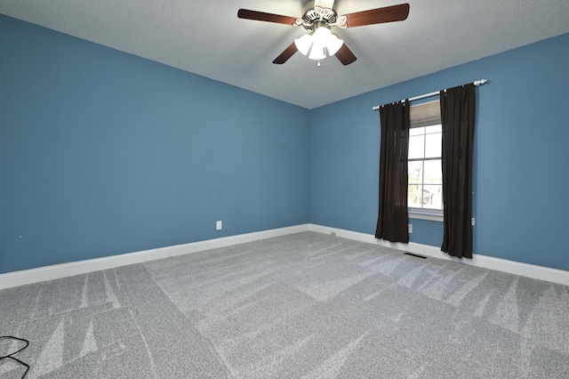 empty room featuring ceiling fan, carpet flooring, and a textured ceiling