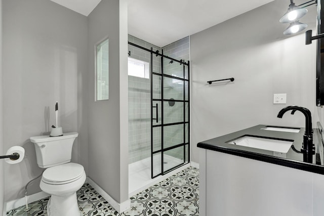 bathroom featuring tile patterned flooring, toilet, baseboards, a sink, and a stall shower