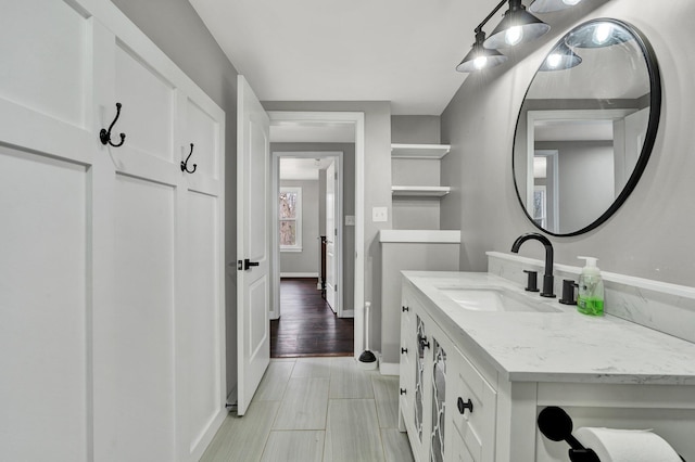 bathroom featuring vanity, baseboards, and wood finished floors