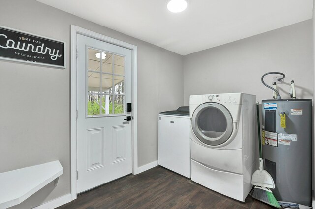 laundry area with washing machine and clothes dryer, laundry area, baseboards, electric water heater, and dark wood-style flooring