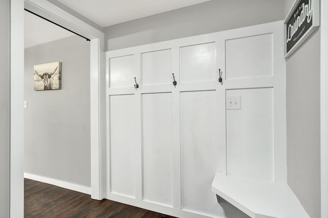 mudroom with dark wood-style flooring and baseboards