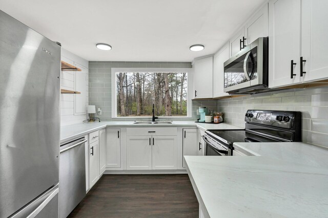 kitchen with dark wood-style floors, a sink, tasteful backsplash, and appliances with stainless steel finishes