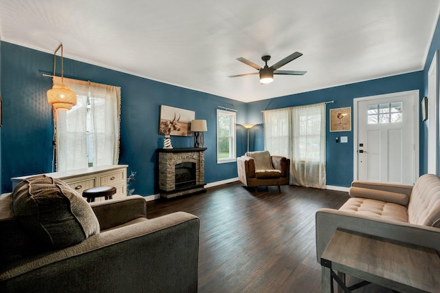 living area with dark wood-type flooring, a ceiling fan, and plenty of natural light