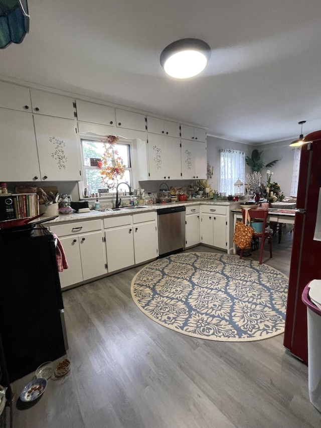 4010 Elm Ln NE, Cleveland, TN 37312 - kitchen with stainless steel dishwasher, a sink, wood finished floors, light countertops, and white cabinets