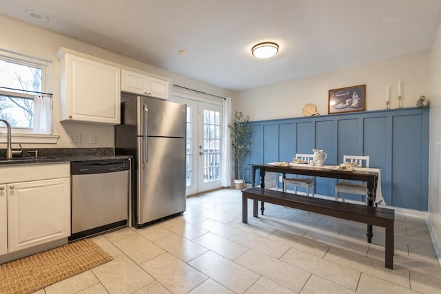 kitchen featuring white cabinets, a healthy amount of sunlight, stainless steel appliances, and a sink