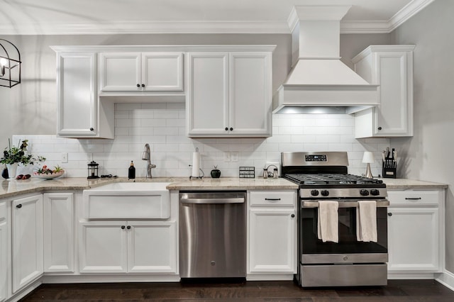 kitchen with white cabinets, light stone countertops, custom range hood, and stainless steel appliances