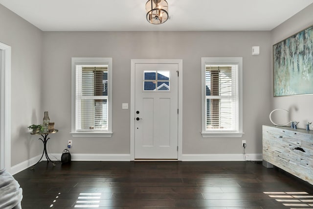 foyer entrance with dark hardwood / wood-style floors and a notable chandelier