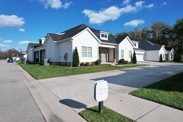 view of front of property featuring cooling unit, a front yard, and a garage