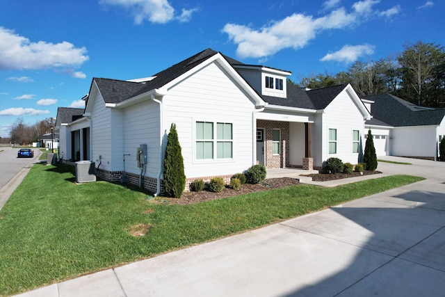 view of front facade featuring covered porch, a front yard, and a garage