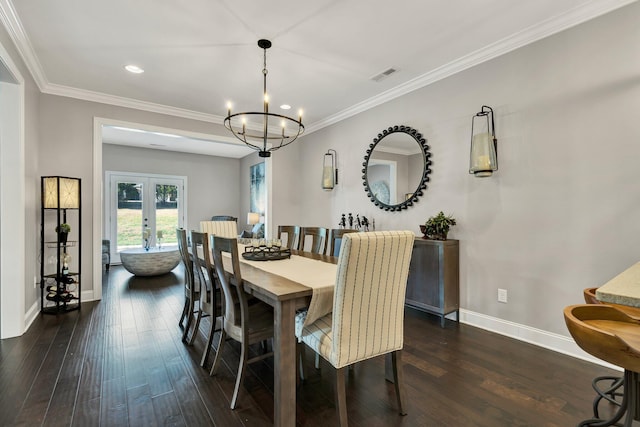 dining area with ornamental molding, french doors, dark wood-type flooring, and a notable chandelier