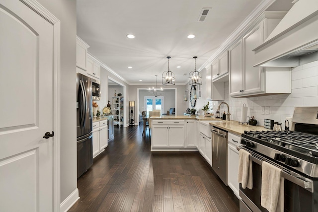 kitchen featuring pendant lighting, white cabinets, custom range hood, kitchen peninsula, and stainless steel appliances