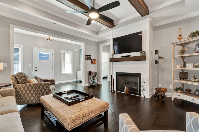 living room with dark hardwood / wood-style floors, ceiling fan, ornamental molding, a fireplace, and beam ceiling