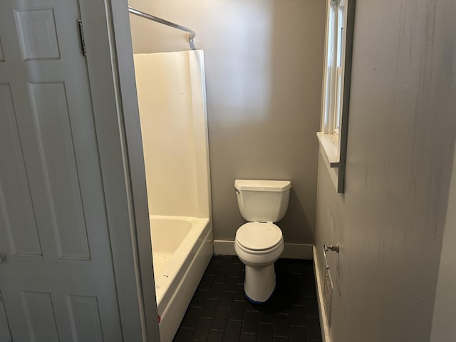 bathroom featuring toilet, shower / bath combo with shower curtain, and baseboards