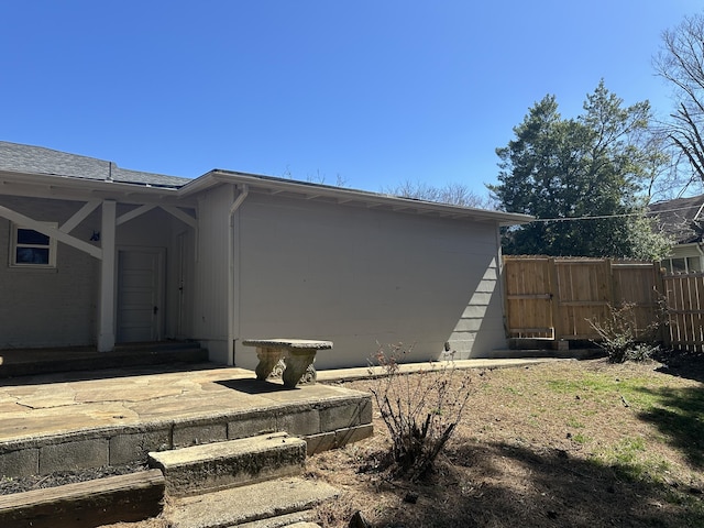 view of side of home featuring fence