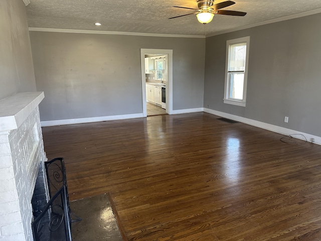 unfurnished living room featuring ceiling fan, a textured ceiling, ornamental molding, and dark wood-style flooring