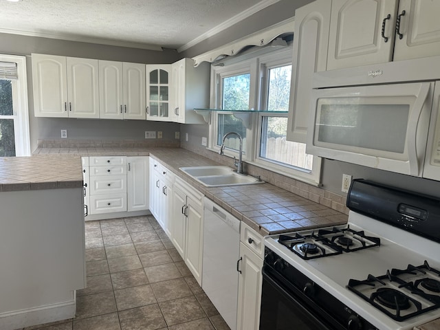 kitchen featuring white appliances, a sink, a textured ceiling, white cabinetry, and crown molding