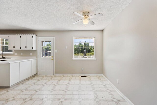 373 Kile Ln SW, Cleveland, TN 37311 - kitchen with a textured ceiling, ceiling fan, white cabinetry, light countertops, and baseboards