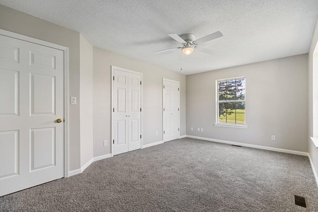 373 Kile Ln SW, Cleveland, TN 37311 - unfurnished bedroom with carpet floors, multiple closets, a textured ceiling, baseboards, and ceiling fan