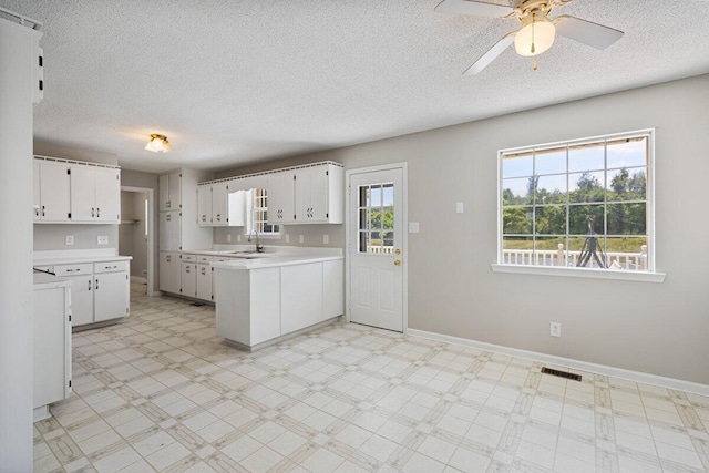 373 Kile Ln SW, Cleveland, TN 37311 - kitchen with a sink, a peninsula, light countertops, a textured ceiling, and ceiling fan