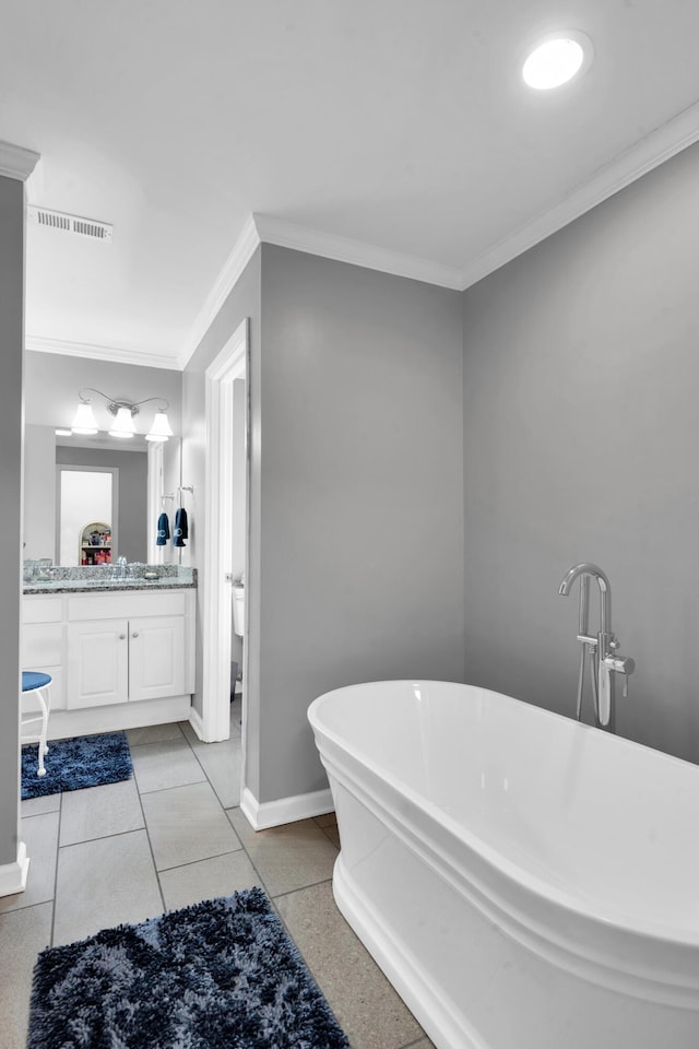 full bathroom featuring crown molding, visible vents, vanity, a freestanding tub, and baseboards