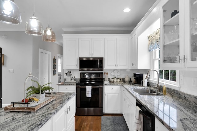 kitchen with black appliances, crown molding, white cabinets, and a sink