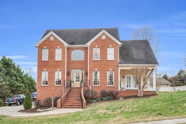 view of front of home featuring roof with shingles, fence, a front lawn, and french doors