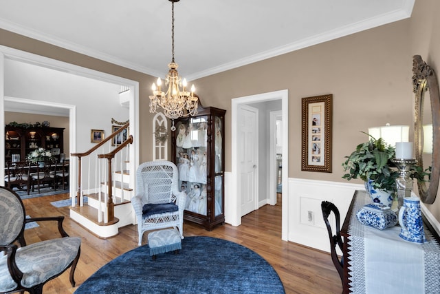 interior space featuring a notable chandelier, stairs, ornamental molding, and wood finished floors