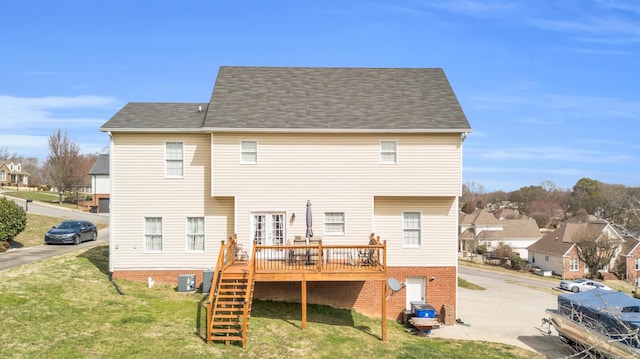 back of house featuring stairs, a yard, brick siding, and a wooden deck