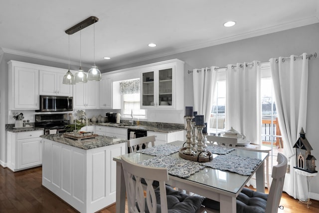 kitchen featuring glass insert cabinets, white cabinetry, appliances with stainless steel finishes, and a center island