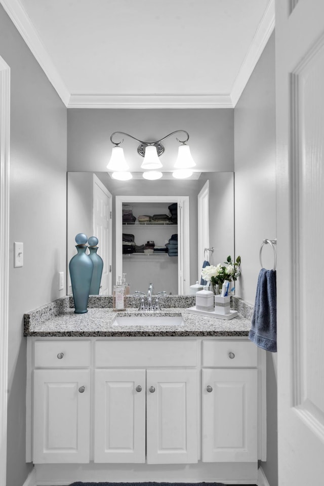 bathroom with ornamental molding and vanity