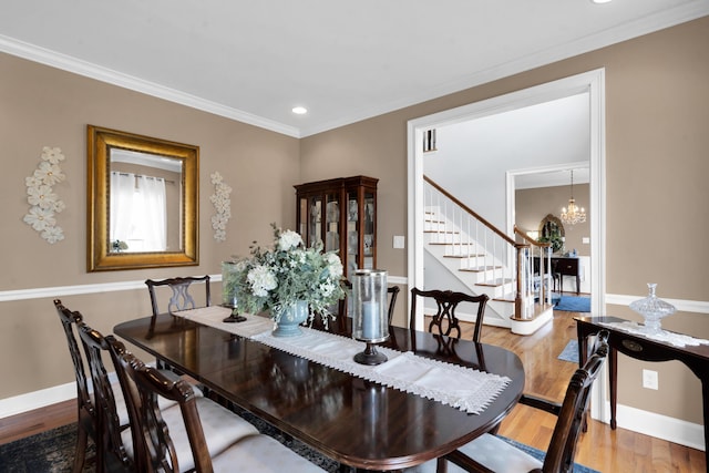 dining area with ornamental molding, stairway, an inviting chandelier, and wood finished floors