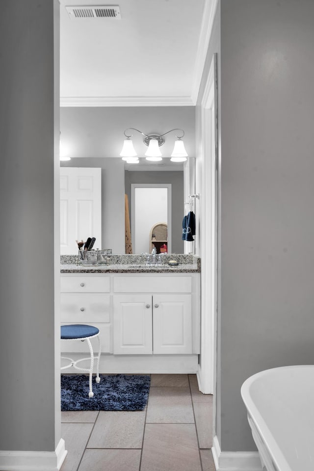 full bathroom with tile patterned flooring, vanity, baseboards, visible vents, and crown molding