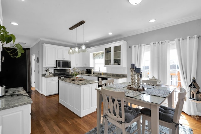 kitchen with white cabinetry, appliances with stainless steel finishes, a center island, dark wood-style floors, and glass insert cabinets