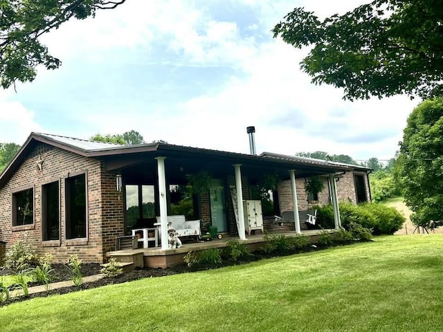 2996 Sugar Grove Valley Rd, Harriman, TN 37748 - rear view of house featuring brick siding, a yard, and covered porch