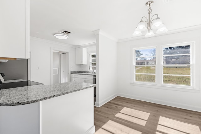 1704 Georgetown Rd NW, Cleveland, TN 37311 - kitchen with a chandelier, white cabinetry, light stone countertops, light wood-type flooring, and ornamental molding