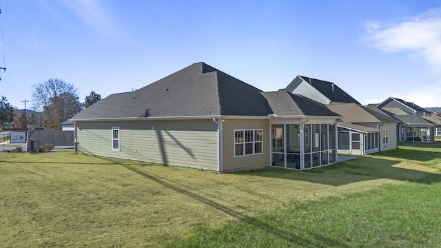 rear view of property with a sunroom and a yard