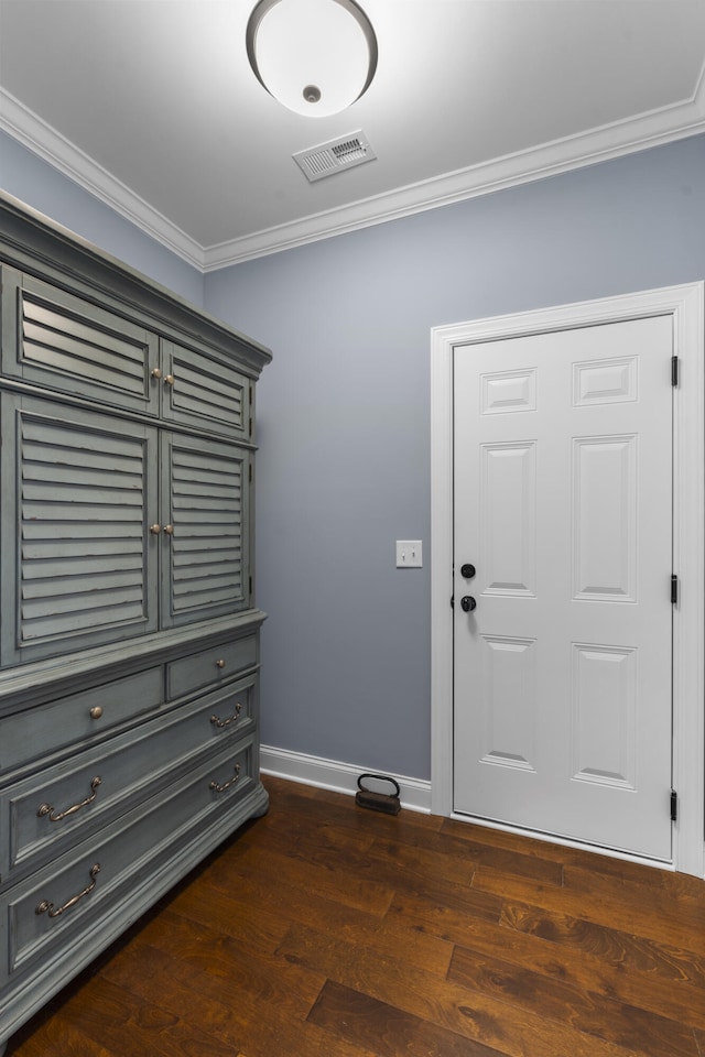 foyer with ornamental molding and dark wood-type flooring