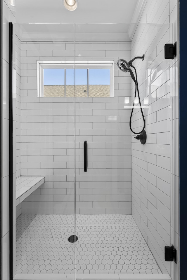 bathroom with crown molding and a shower with shower door