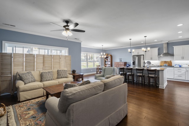 living room featuring crown molding, sink, dark hardwood / wood-style floors, and ceiling fan with notable chandelier