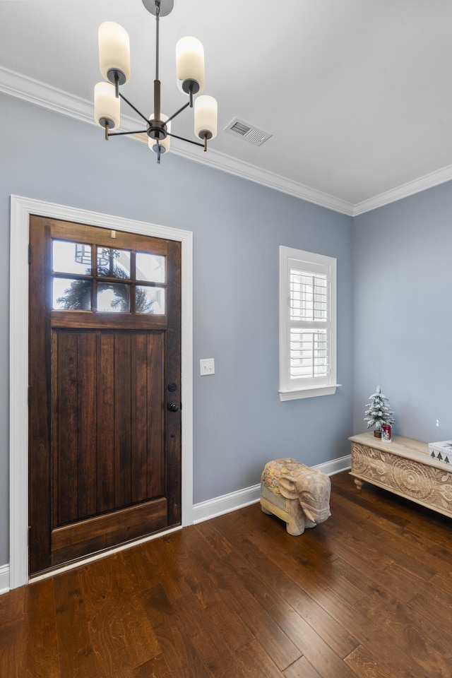 foyer entrance featuring plenty of natural light, wood-type flooring, ornamental molding, and a chandelier